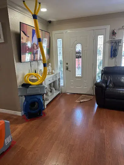 Air movers and extraction hose set up in the entry of a Brooksville home