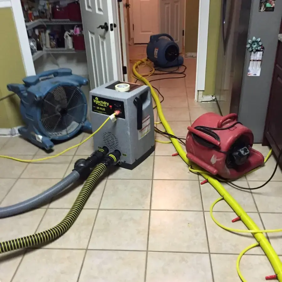 Air movers and a dehumidifier drying a tiled Brooksville hallway