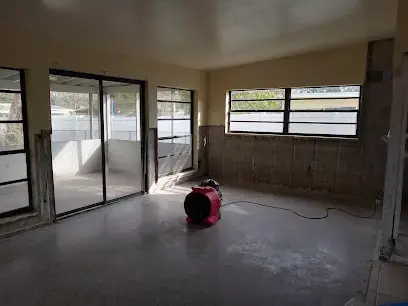 Flood-cut walls and an air mover drying a Brooksville room after storm water