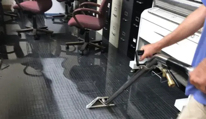 Extraction wand pulling floodwater from office carpet tile in a Brooksville business