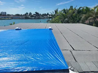 Emergency tarp over a storm-damaged Florida roof to stop a roof leak