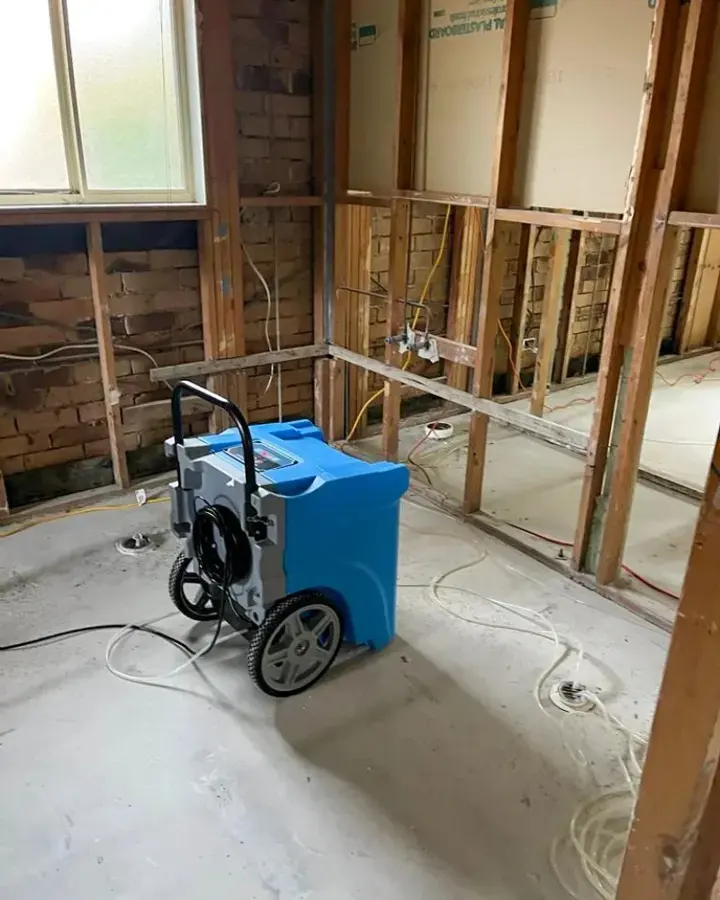 Dehumidifier drying opened wall framing during a Brooksville structural dry-out